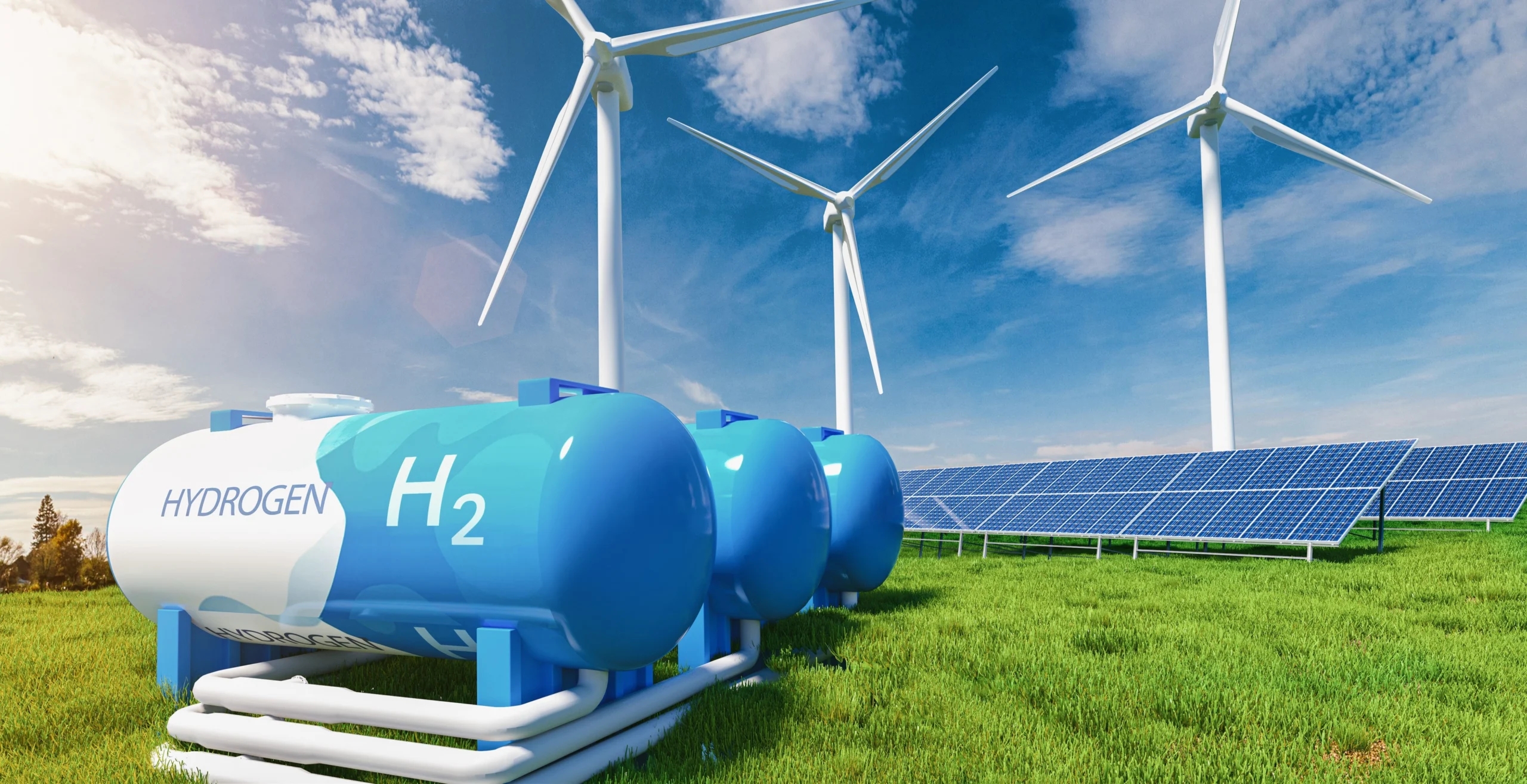 Wasserstofftanks stehen auf einer grünen Wiese. Hinter ihnen stehen Windräder und Solarzellen.